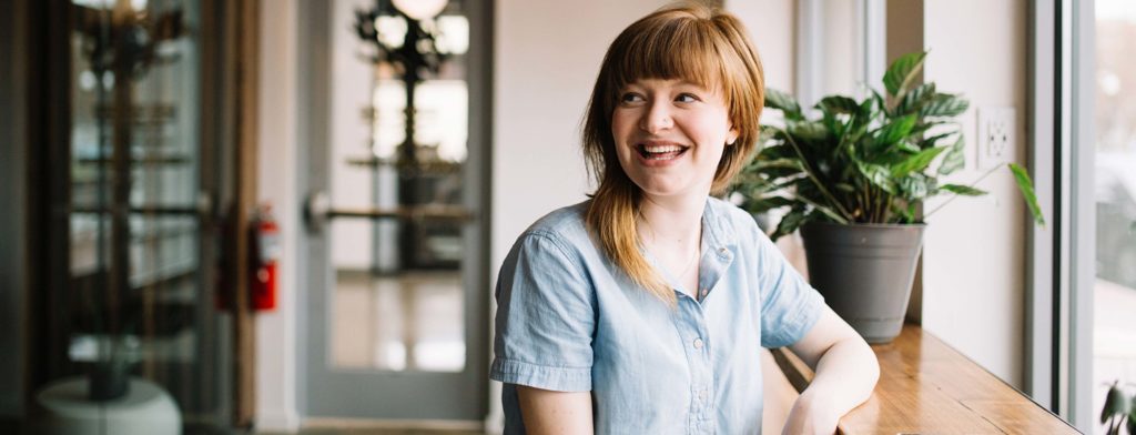 A woman standing at a desk in a medical centre.