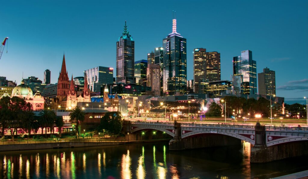 The Princes Bridge at night, with the city of Melbourne illuminated in the background.
