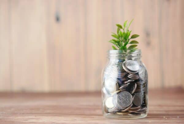 Financial Wellbeing for young people with CF | Jar of coins with leaves on table